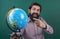 look over there. back to school. informal education. happy mature teacher pointing at globe. bearded man geographer work