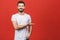 Look over there! Happy young handsome man in casual pointing away and smiling while standing against red background