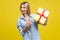 Look at this present! Portrait of excited woman pointing at wrapped gift box. satisfied with holiday surprise. indoor studio shot