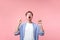 Look there, crazy news! Portrait of shocked brunette man pointing up at copy space. indoor isolated on pink background