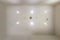 Look up on suspended ceiling with halogen spots lamps and drywall construction with fire alarm sensor in empty room in apartment