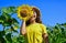 Look at it. yellow flower of sunflower. happy childhood. beautiful girl wear straw summer hat in field. pretty kid with