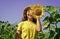 Look at it. yellow flower of sunflower. happy childhood. beautiful girl wear straw summer hat in field. pretty kid with