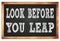 LOOK BEFORE YOU LEAP words on black wooden frame school blackboard