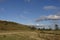 Looking across the floor of a small valley with a meandering stream, with Cattle on the Hill side.