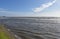 Looking across incoming tide to distant pier