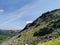 Looking across rock hillside to distant climbers