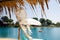 Looking at the blue sky and the sun`s rays through a straw beach umbrella and hanging beads from feather and yarn