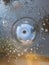 Looking down into a garden pond and the top of a water fountain and the orange fishes swimming