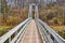 Looking down large suspension bridge over river in Michigan park