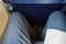Looking down at narrow leg space in low cost airline seat, knees touching back rest at front
