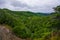 Looking down over Tongariro National Park from the side of Mangawhero River, forest stream flowing over rocky riverbed