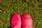 Looking down pink color shoes rubber on grass.woman in rubber boots walking in the rain. girl wearing pink rain boots