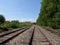 Looking down railway lines with trees on the right