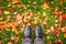 Looking down at shoes, colorful autumnal leaves on the ground, autumn concept