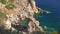 Looking down from tall rocky cliffs at Paleokastritsa, Corfu Greece, calm clear green sea water below