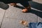 Looking down towards two pairs of feet walking on black city paving in late afternoon sun