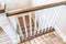 Looking down on U shaped indoor staircase with white baluster and brown handrail