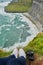 Looking down at the world. High angle shot of an unrecognizable woman sitting on cliff and admiring the view.