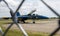 Looking through a fence at a US Navy Blue Angels jet parked at airport
