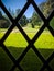 Looking out on a long driveway from a lattice window