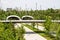 Looking out over highway tunnel and pedestrian overpass near park and Arkansas River with newly planted trees and wildflowers and