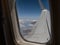 Looking Outside a Window of an Aircraft Cabin: White Airplane Wing and Clouds