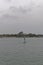 Looking past a green channel Navigation Buoy near to the Coastline of Conakry