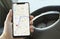 Looking at phone Google Maps Navigator. Hand with a smartphone in the car. Google is the biggest Internet search engine in the