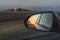 Looking through a side mirrors with a sunset in it