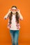 Looking trendy. Fashionable party girl on orange background. Adorable party girl wearing fancy glasses. Cute small child