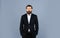 Looking trendy. handsome man standing on gray background. serious bearded businessman. stylish mature man looking modern