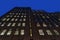 Looking up at a facade of a tall brick building on Manhattan`s Upper East Side at night, New York City