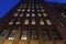 Looking up at a facade of a tall brick building on Manhattan`s Upper East Side at night, New York City