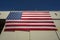 Looking up at a giant  American flag on the side of a hangar building