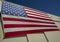 Looking up at a giant American flag on the side of a hangar building