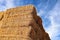 Looking up a hay bale stack against a blue sky