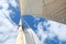 Looking up the mast on a sailing yacht, focussed on the flag at the masthead