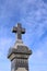 Looking up at an old stone grave monument with blue sky