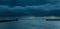 Looking up the River Tyne out to the North Sea at dawn, as large grey rain clouds loom over the Piers