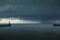 Looking up the River Tyne out to the North Sea at dawn, as large grey rain clouds loom over the Piers