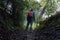 Looking up at a sunken path though woodland. On a wet, moody summers day. With a double exposure of a half transparent hiker. UK