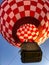 Looking up at tethered red and white checkered hot air balloon at festival