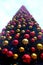 Looking up to the top of a very large christmas tree covered in hundreds of red and gold christmas baubles