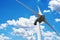 Looking up to a wind turbine generating electricity in a sunny day