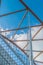 Looking up at the top architectural structure of an interstate bridge with blue skies and puffy white cloud in the background - di