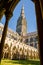 Looking up at the towering spire of Salisbury Cathedral through the Gothic cloisters on a sunny Spring day