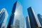 Looking up view in financial district, the silhouettes of skyscrapers city reflect blue sky, sun lights in Tokyo, Japan