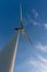 Looking up at a wind turbine, blue sky and white clouds