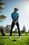 Looking at where the ball will go. a focused young male golfer about to swing and play a shot with his golf club outside